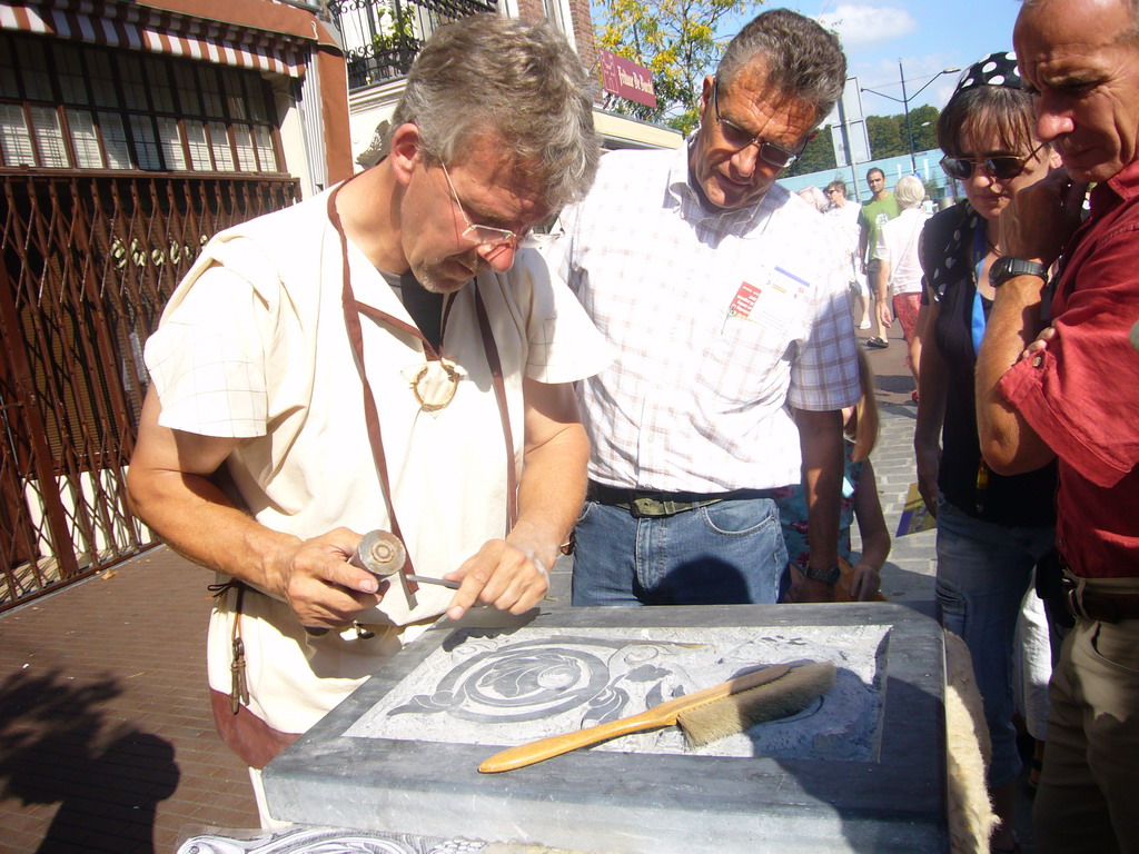 Person in medieval clothes making art at the Broerstraat street, during the Gebroeders van Limburg Festival