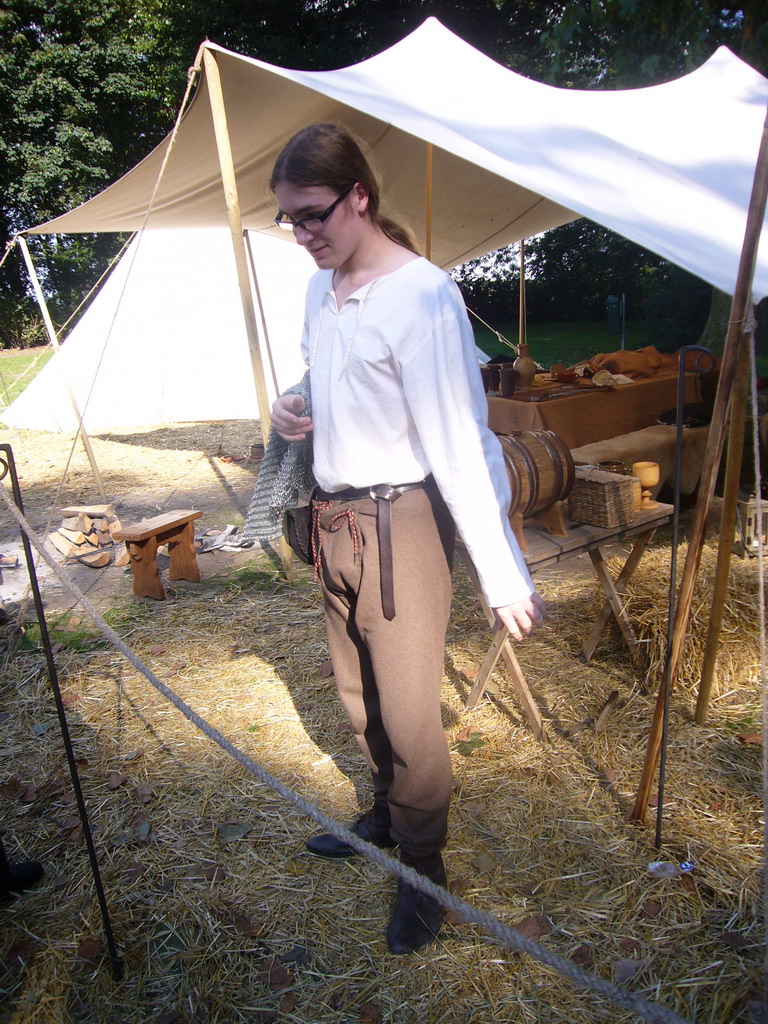 Person in medieval clothes holding armour at the Valkhof park, during the Gebroeders van Limburg Festival