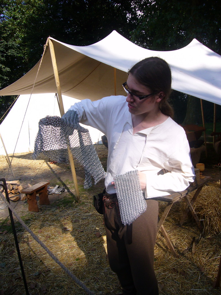 Person in medieval clothes holding armour at the Valkhof park, during the Gebroeders van Limburg Festival