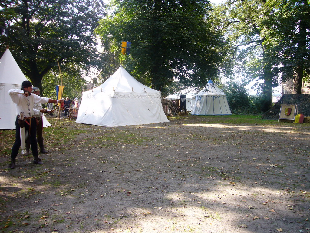 People in medieval clothes shooting arrows at the Valkhof park, during the Gebroeders van Limburg Festival