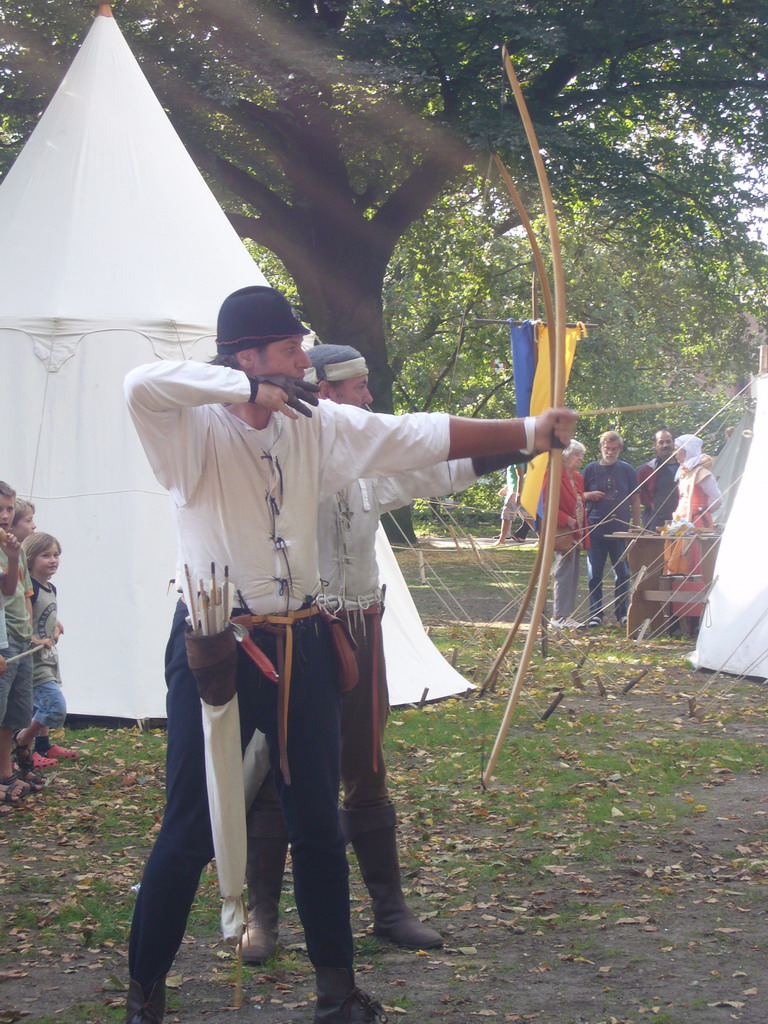 People in medieval clothes shooting arrows at the Valkhof park, during the Gebroeders van Limburg Festival