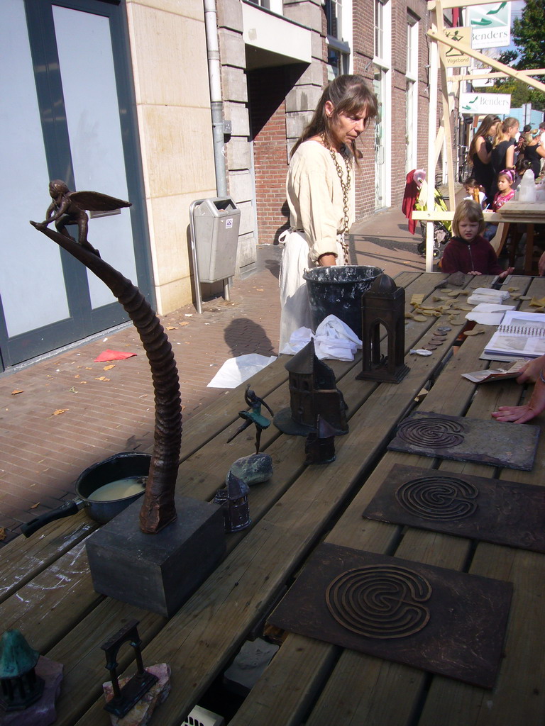 Person in medieval clothes selling art at the Broerstraat street, during the Gebroeders van Limburg Festival