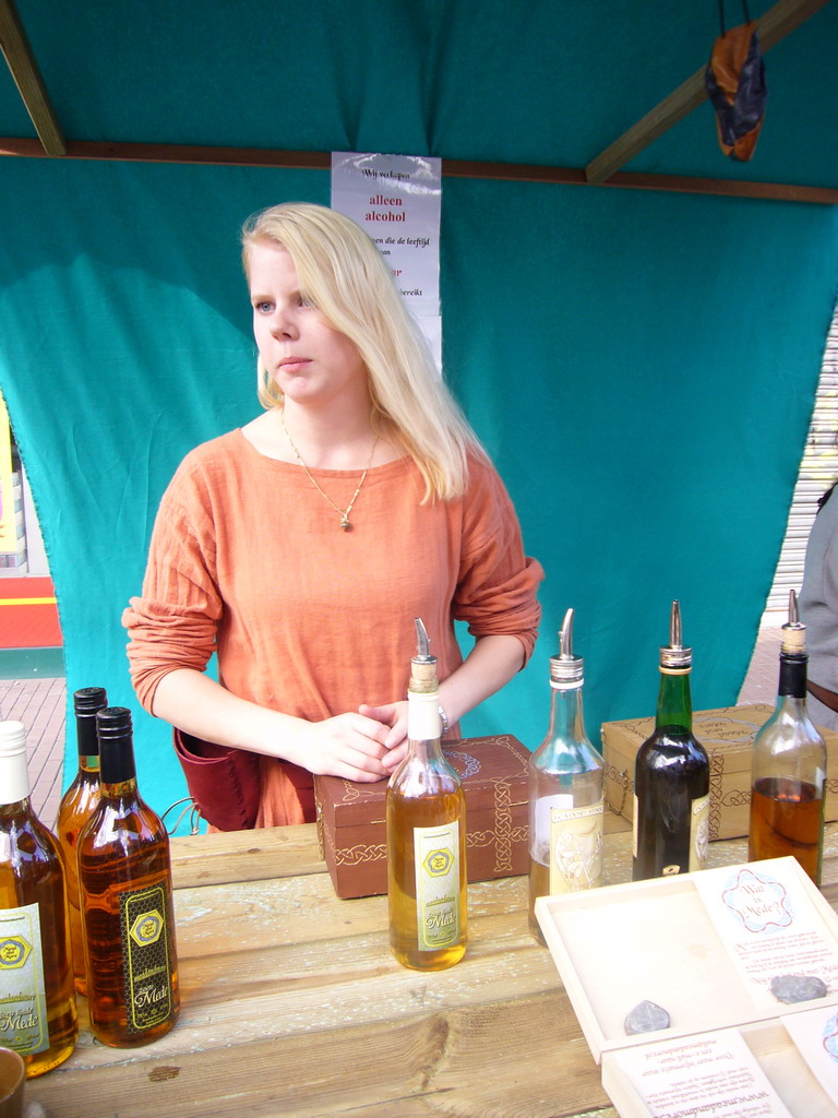 Person in medieval clothes selling wine at the Broerstraat street, during the Gebroeders van Limburg Festival