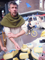 Person in medieval clothes selling cheese at the Broerstraat street, during the Gebroeders van Limburg Festival