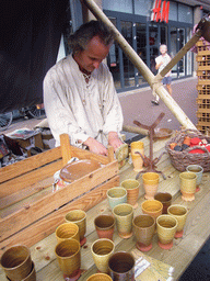 Person in medieval clothes selling pottery at the Broerstraat street, during the Gebroeders van Limburg Festival