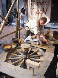Person in medieval clothes selling pottery at the Broerstraat street, during the Gebroeders van Limburg Festival