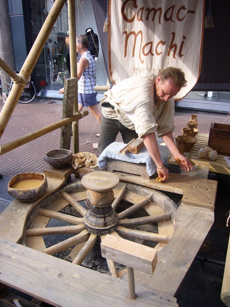 Person in medieval clothes selling pottery at the Broerstraat street, during the Gebroeders van Limburg Festival