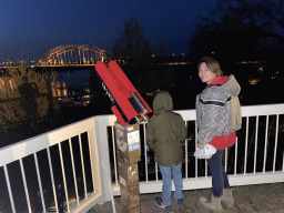 Miaomiao and Max at the Valkhof park, with a view on the Waalbrug bridge over the Waal river, by night
