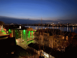 The Waal river with the Nijmegen railway bridge and the Oversteek bridge, the Groene Balkon and Vleeshouwerstraat streets and the `Prinses uit het Oosten` wall painting, viewed from the Valkhof park, by night