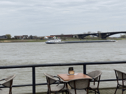 Boat and Waalbrug bridge over the Waal river, viewed from the Waalkade street
