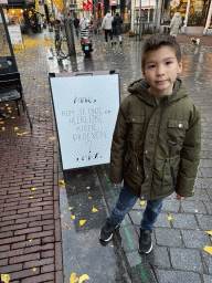 Max with a sign in front of the Anne & Max café at the Lange Hezelstraat street
