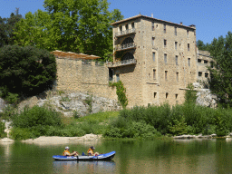 Small boat at the north side of the Gardon river and a building on the northwest side of the Pont du Gard aqueduct bridge