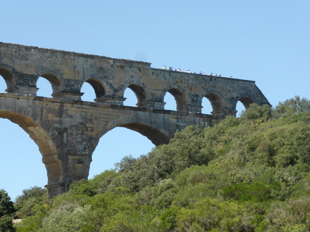 People walking at the northwest side of the top floor of the Pont du Gard aqueduct bridge