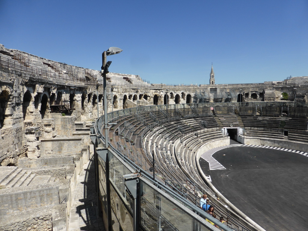 The northeast side of the interior of the Arena of Nîmes and the tower of the Eglise Sainte Perpétue church, viewed from the upper middle rows of seats