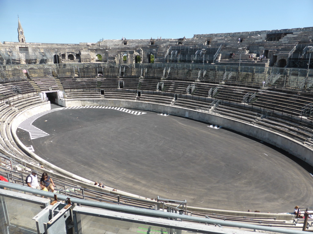 The east side of the interior of the Arena of Nîmes and the tower of the Eglise Sainte Perpétue church, viewed from the upper middle rows of seats