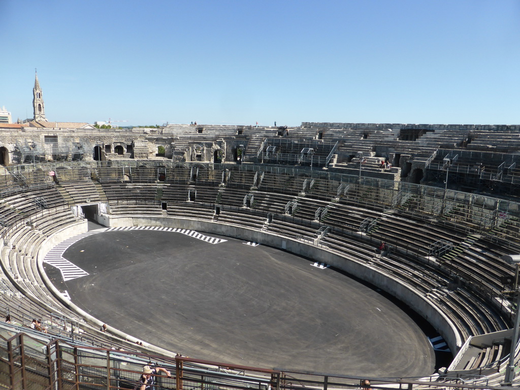 The east side of the interior of the Arena of Nîmes and the tower of the Eglise Sainte Perpétue church, viewed from the top rows of seats