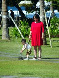 Miaomiao and Max playing with a lawn sprinkler at the grassfield of the Inaya Putri Bali hotel