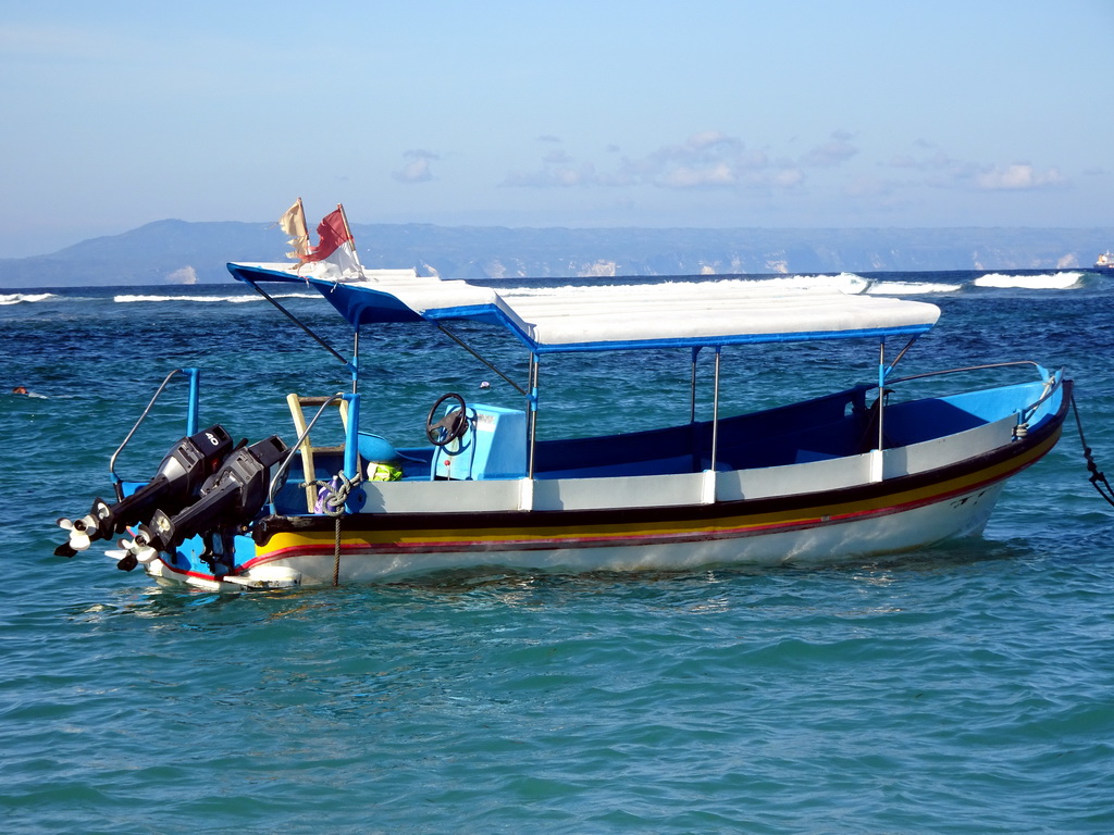 Boat in the Lombok Strait, viewed from the beach of the Inaya Putri Bali hotel