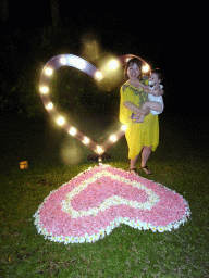 Miaomiao and Max at a heart-shaped flower bed at the Kayumanis Nusa Dua Private Villa & Spa, by night