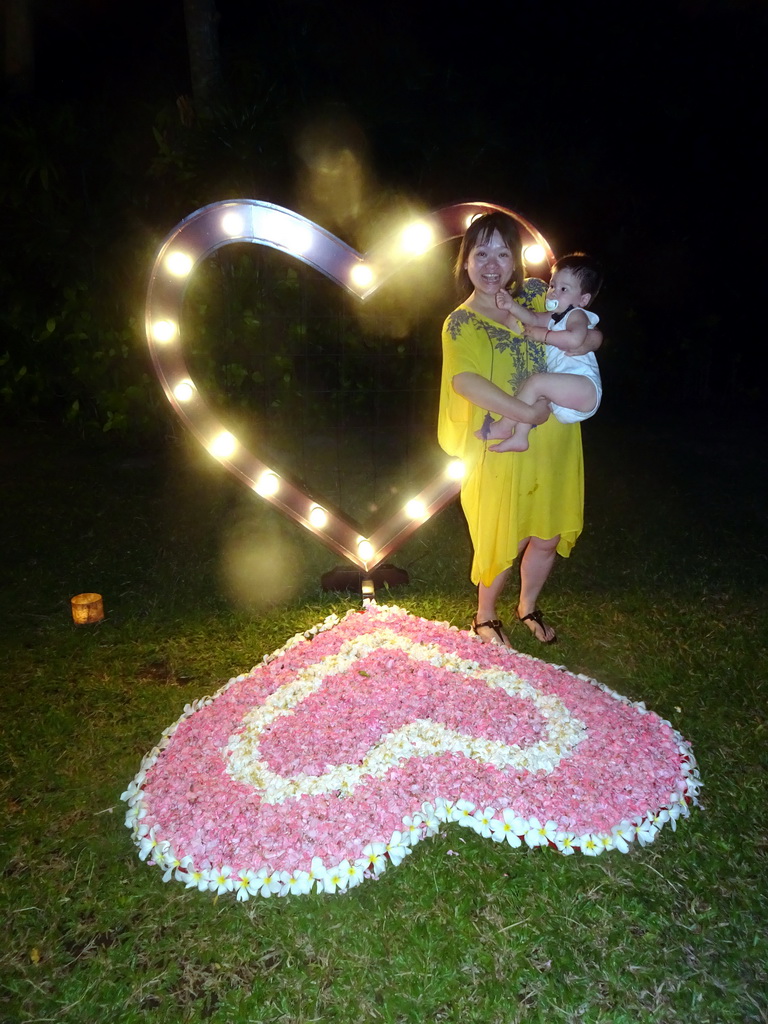 Miaomiao and Max at a heart-shaped flower bed at the Kayumanis Nusa Dua Private Villa & Spa, by night