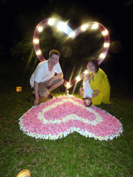 Tim, Miaomiao and Max at a heart-shaped flower bed at the Kayumanis Nusa Dua Private Villa & Spa, by night