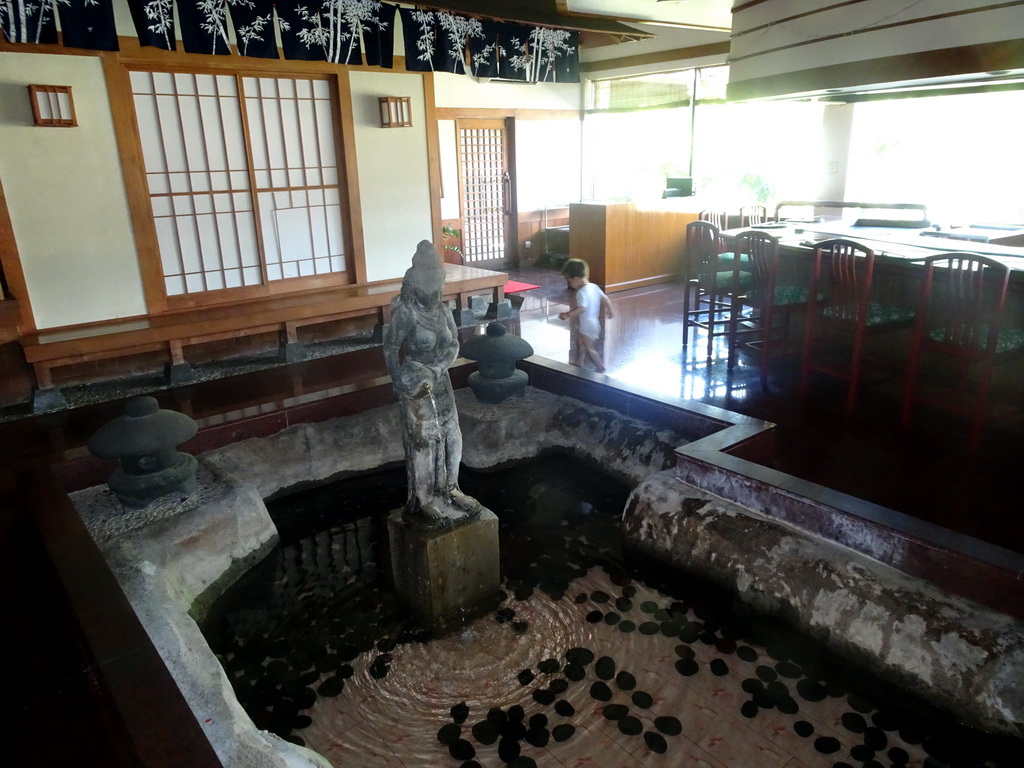 Max at a pond with a statue at the Matsuri restaurant at the Bali Collection shopping mall