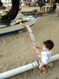 Max playing with a boat at the beach of the Inaya Putri Bali hotel