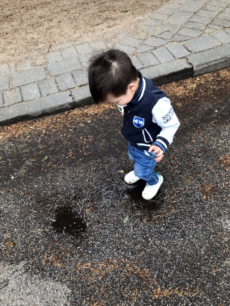 Max playing with water on a street at the Roompot De Katjeskelder holiday park