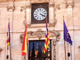 Flags and clock at the facade of the City Hall at the Plaça de Cort square