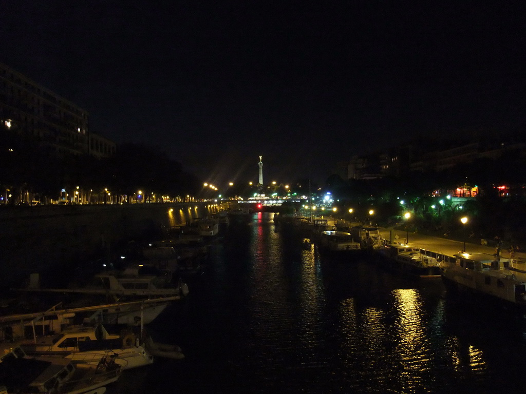 Boats in the Bassin de l`Arsenal basin and the Colonne de Juillet column, by night
