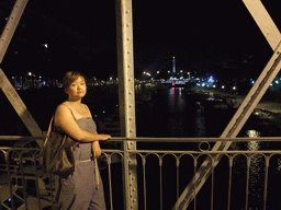 Miaomiao at a bridge over the Bassin de l`Arsenal basin, and the Colonne de Juillet column, by night