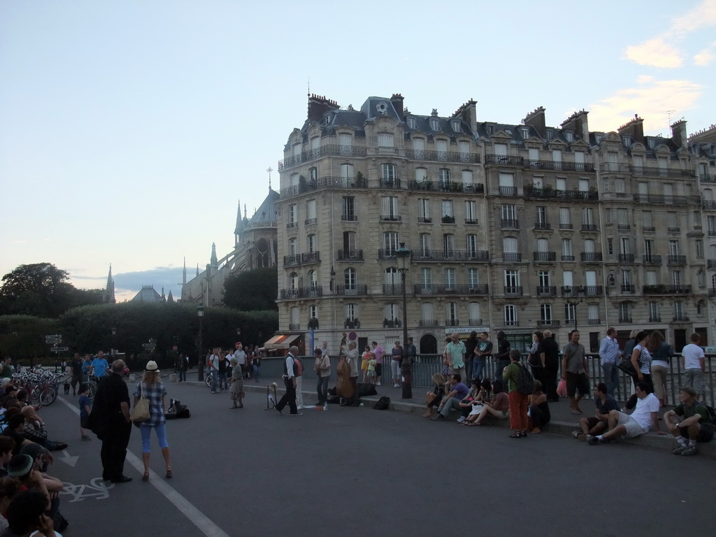 Street artists on the Pont Saint-Louis bridge and the back side of the Cathedral Notre Dame de Paris