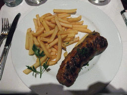 Andouillette sausage with fries in the restaurant `Maison de l`Alsace` in the Avenue des Champs-Élysées