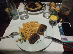 Andouillette sausage with fries and porc in the restaurant `Maison de l`Alsace` in the Avenue des Champs-Élysées