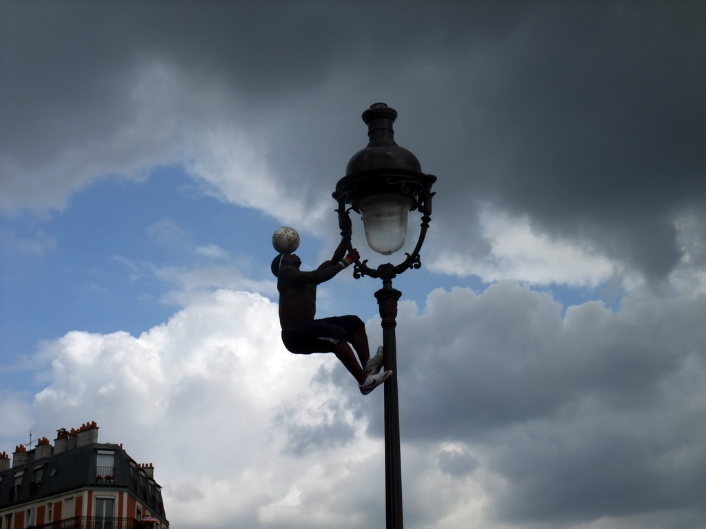 Street artist with football, hanging on a street light on top of the Montmartre hill