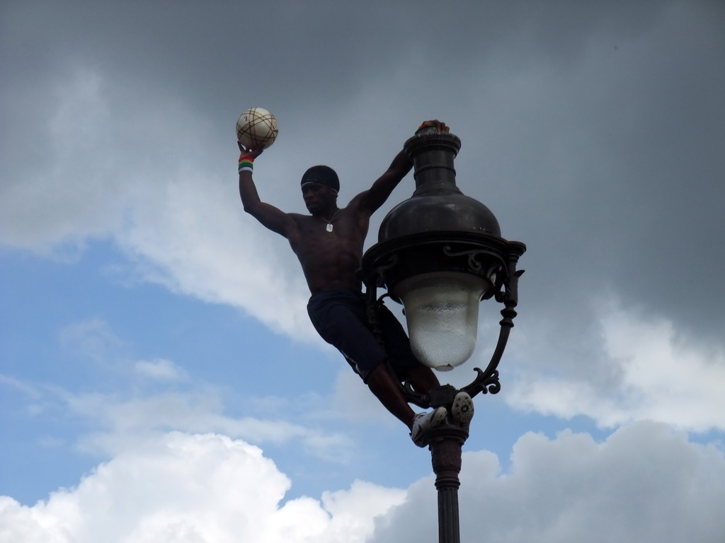 Street artist with football, hanging on a street light on top of the Montmartre hill