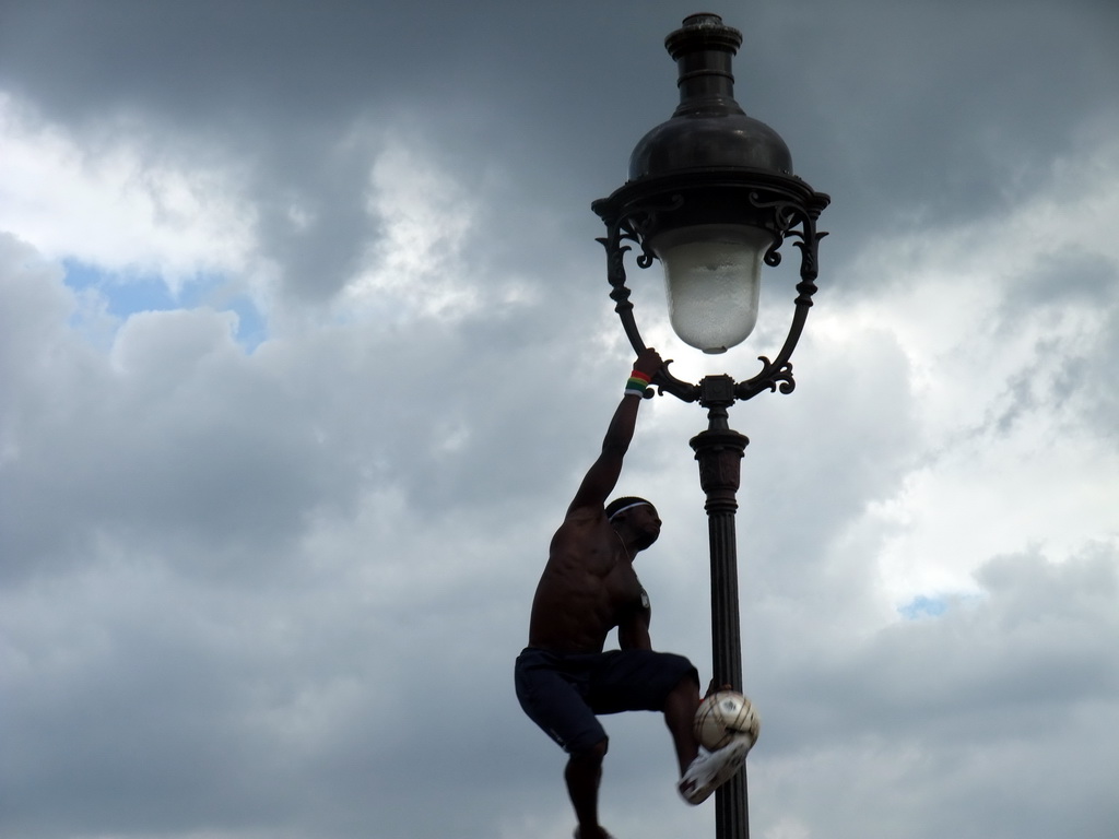 Street artist with football, hanging on a street light on top of the Montmartre hill