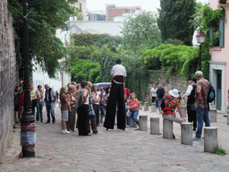 Stiltwalker in the Rue de l`Abreuvoir street on the Montmartre hill