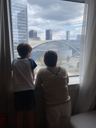 Miaomiao and Max in front of the window of our room at the Pullman Paris La Défense hotel, with a view on the Parvis de la Défense square with the Tour Sequoia tower, the CNIT shopping mall and the Le Pouce statue
