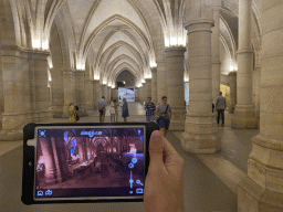 Tim with an iPad showing what the Hall of the Men-at-arms looked like, at the Hall of the Men-at-arms at the Conciergerie building
