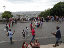 Musician at the Parvis du Sacré-Coeur square and the city center, viewed from the front of the Basilique du Sacré-Coeur church