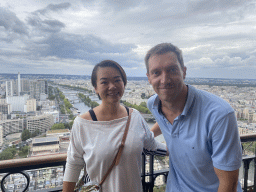 Tim and Miaomiao at the Second Floor of the Eiffel Tower, with a view on the Île aux Cygnes island in the Seine river