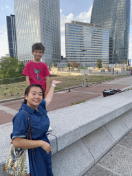 Miaomiao and Max at the Parvis de la Défense square, with a view on the front of the Pullman Paris La Défense hotel and skyscrapers at the Avenue de l`Arche
