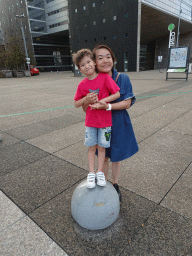 Miaomiao and Max in front of the Immeuble Les Collines de L`Arche building at the Parvis de la Défense square, at sunset
