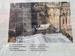 Photograph `A rope access technician verifies the installations meant to protect the Cathedral - Gable of the west facade` at the exhibition `Notre-Dame de Paris - The first months of a renaissance` at the Rue du Cloître-Notre-Dame street, with explanation
