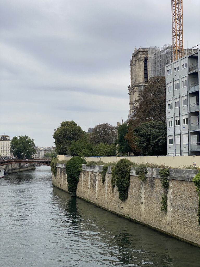 The Pont au Double bridge over the Seine river and the towers of the Cathedral Notre Dame de Paris, under renovation, viewed from the Pont de l`Archevêché bridge