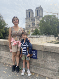 Miaomiao and Max at the Petit Pont bridge over the Seine river, with a view on the front of the Cathedral Notre Dame de Paris, under renovation