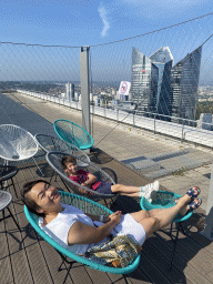 Miaomiao and Max in lounge chairs at the top floor of the Grande Arche de la Défense building, with a view on the Tours Société Générale towers