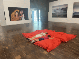 Miaomiao and Max on a mattress at the exhibition `Hymne à la Beauté` at the top floor of the Grande Arche de la Défense building