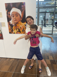 Miaomiao and Max with a photograph of a young monk at the exhibition `Hymne à la Beauté` at the top floor of the Grande Arche de la Défense building